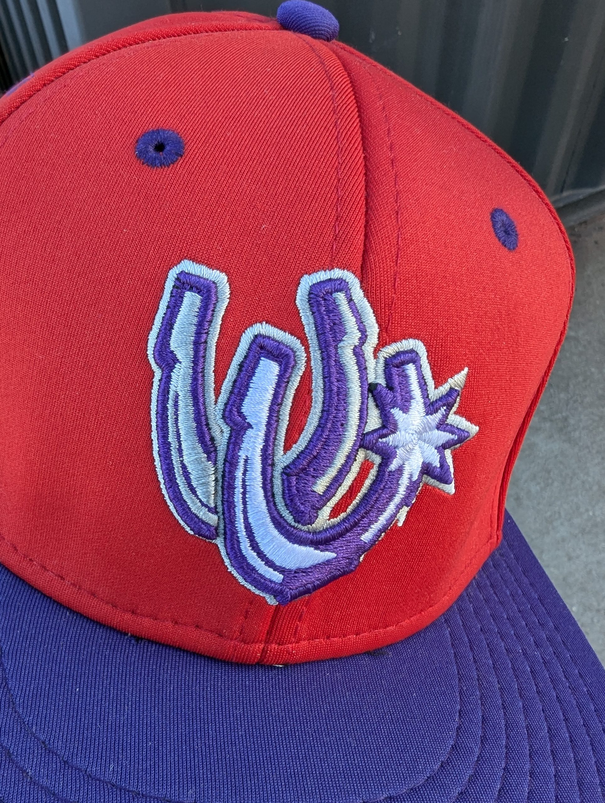 Utica Unicorns away game baseball cap, red with purple bill and UU lettermark logo