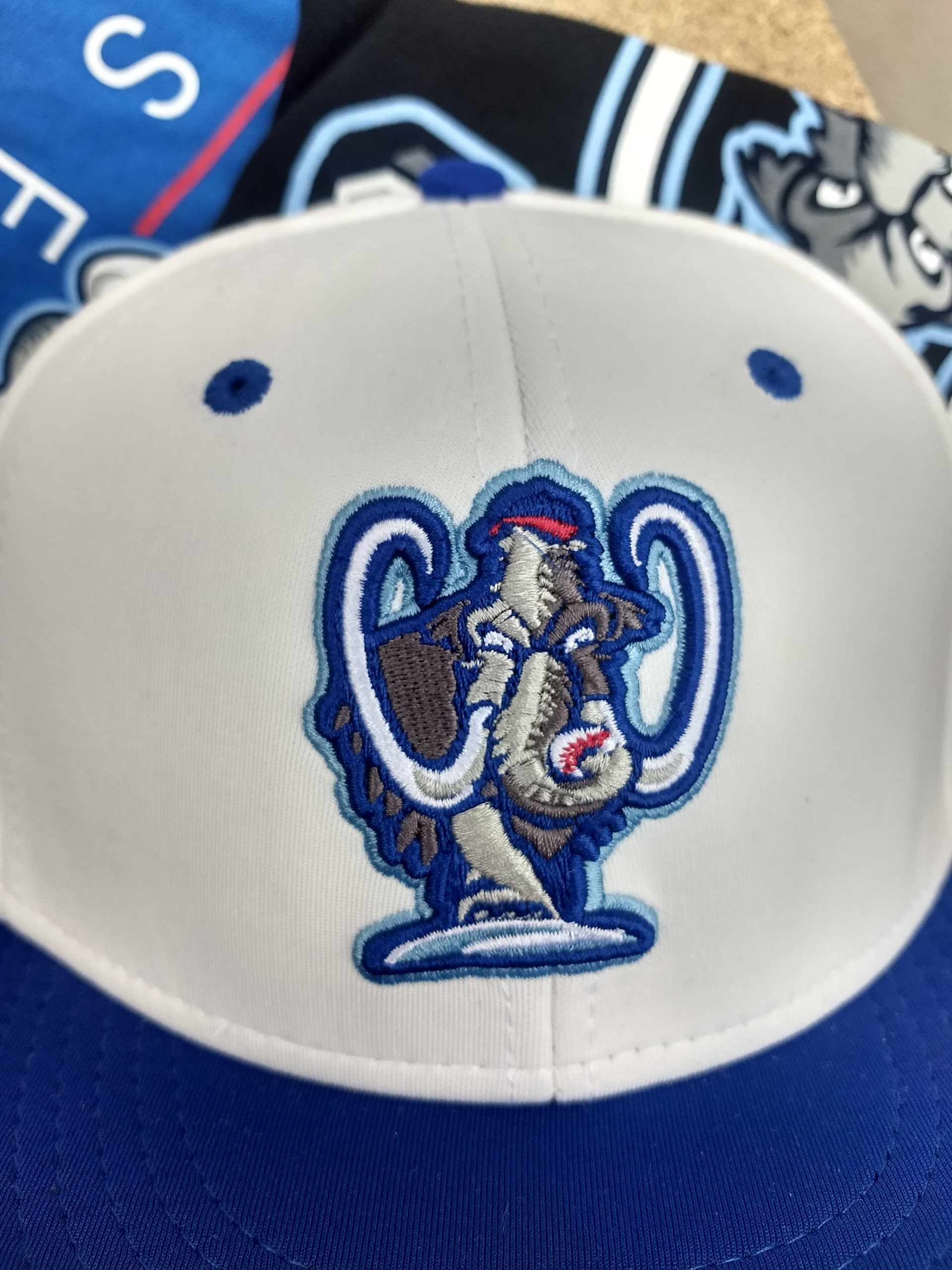 close up of Westside Woolly Mammoths team logo on home game baseball cap, white with royal blue